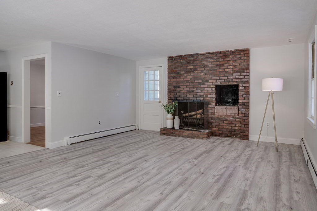 76 Brook Trail Road Concord, MA 01742 - Photo 15 of 33 a view of empty room with wooden floor and fireplace