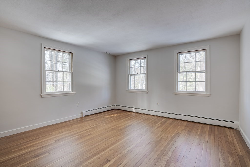 76 Brook Trail Road Concord, MA 01742 - Photo 22 of 33 an empty room with wooden floor and windows