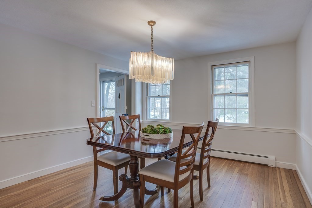 76 Brook Trail Road Concord, MA 01742 - Photo 7 of 33 a dining room with furniture wooden floor a potted plant and a chandelier