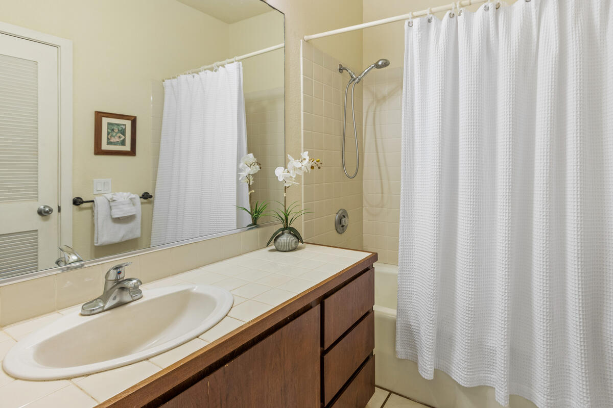 2371 Ho'ohu Road, Unit 801 Koloa, HI 96756 - Photo 16 of 28 a bathroom with a granite countertop sink and a mirror a