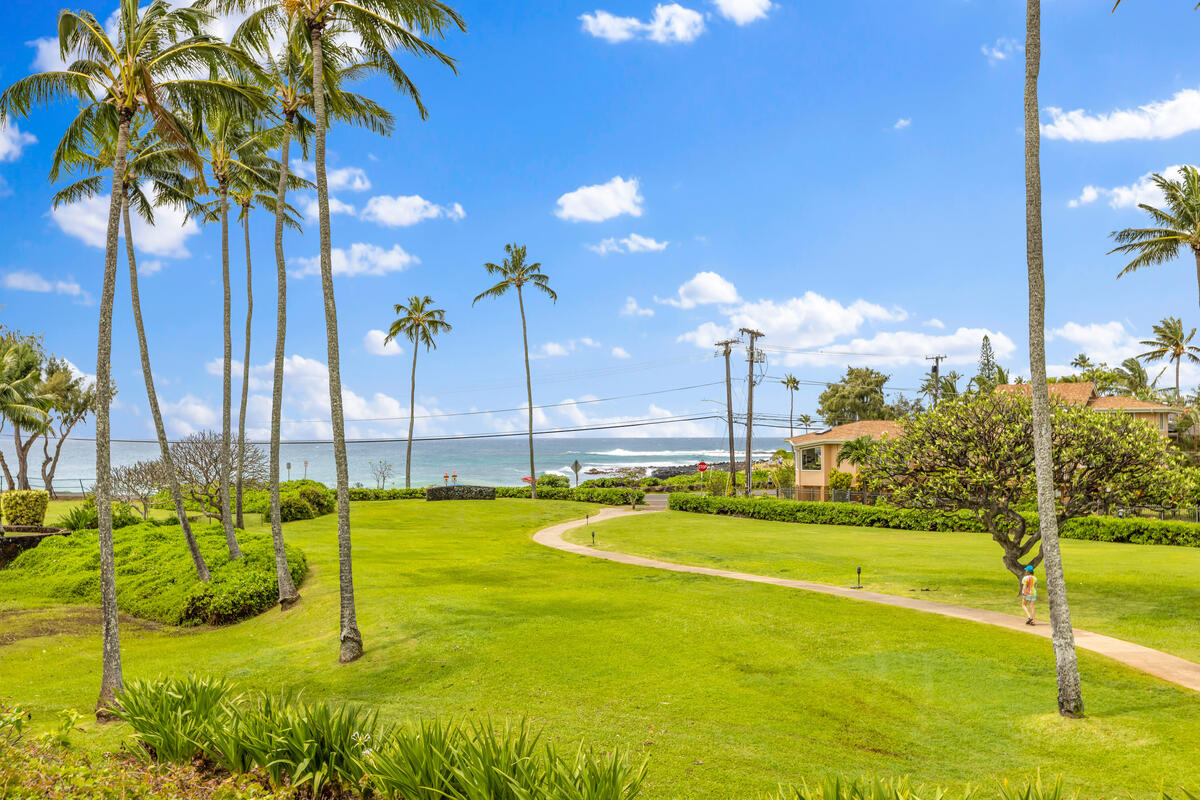 2371 Ho'ohu Road, Unit 801 Koloa, HI 96756 - Photo 24 of 28 a view of a swimming pool with a lawn chairs and palm trees