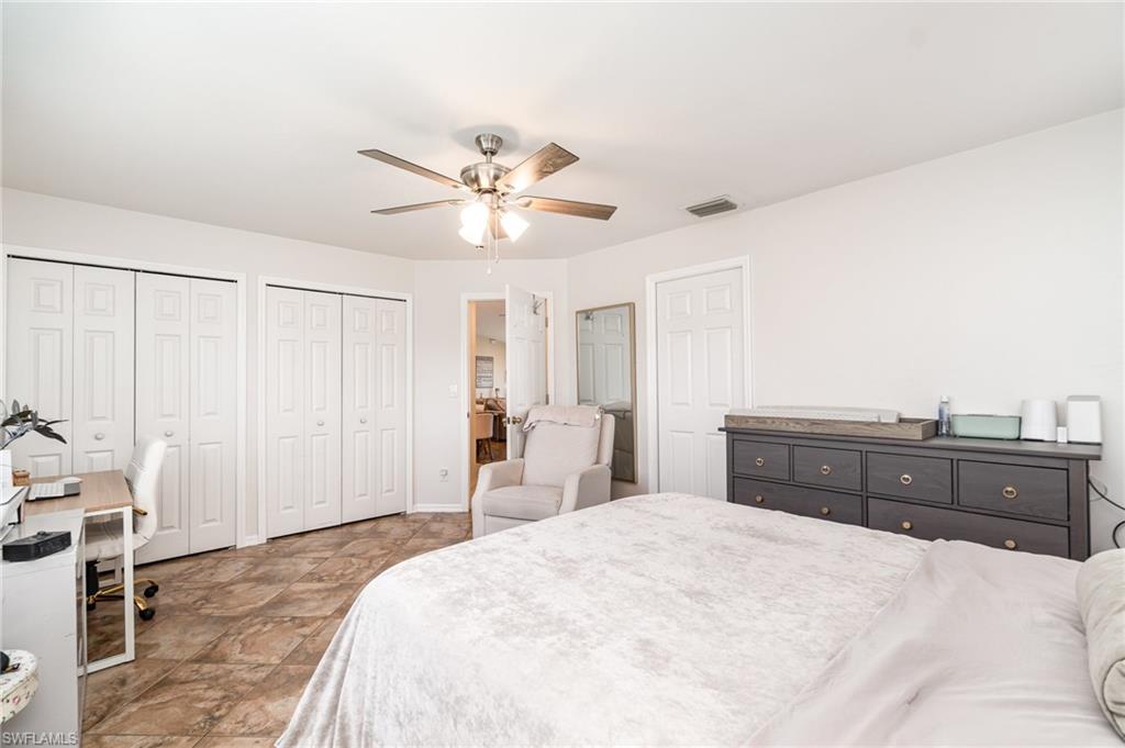 879 Rue Labeau Circle Fort Myers, FL 33913 - Photo 21 of 27 a spacious bedroom with a large bed and a chandelier