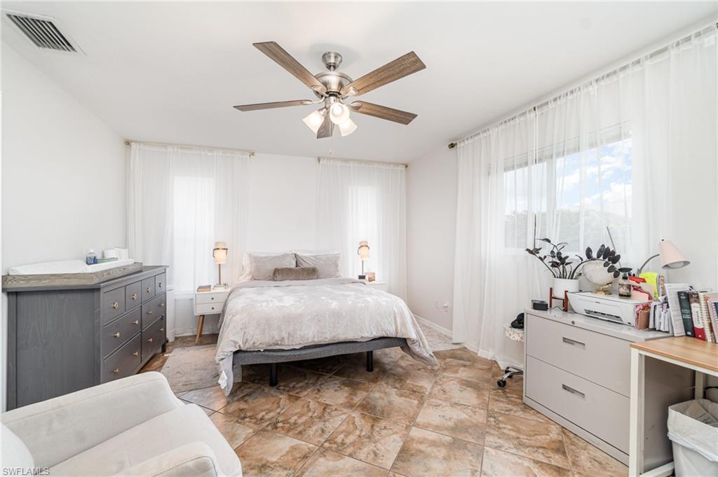 879 Rue Labeau Circle Fort Myers, FL 33913 - Photo 22 of 27 a bedroom with a bed and a chandelier