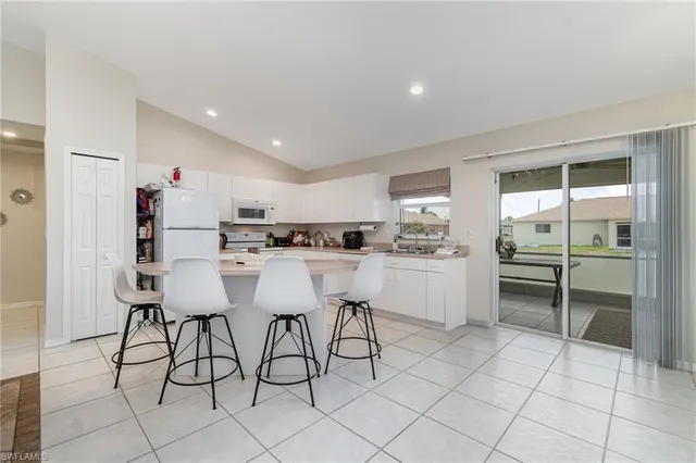 a kitchen with a sink cabinets and chairs