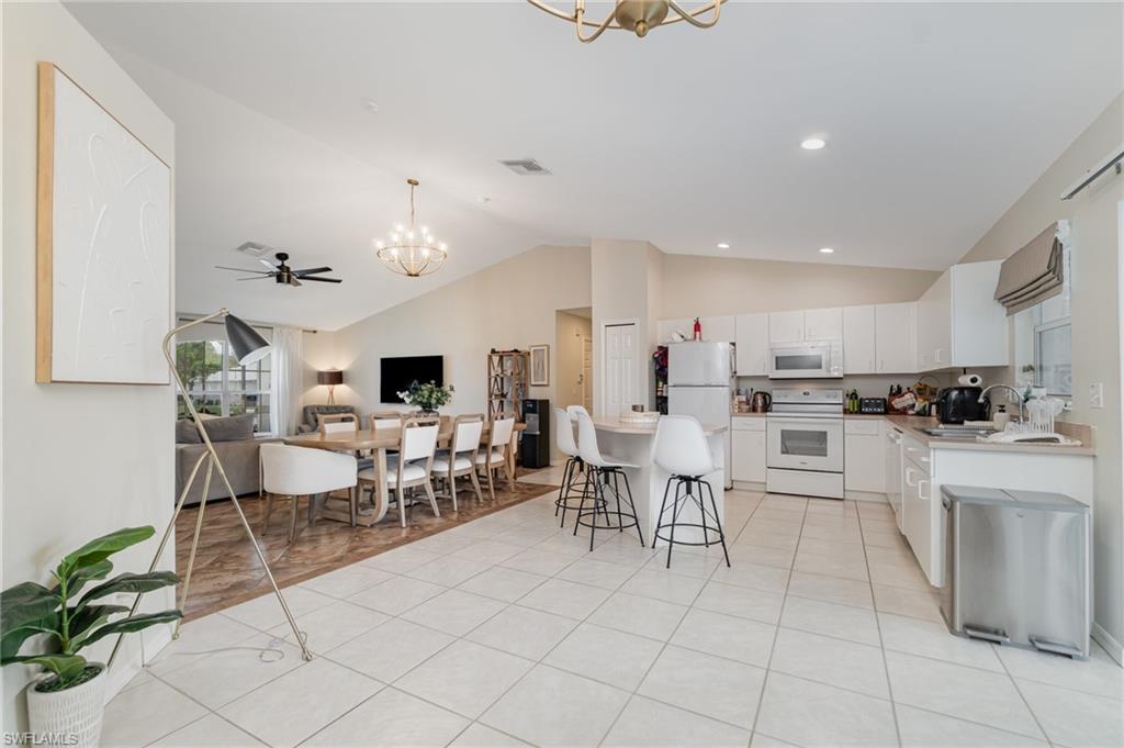 879 Rue Labeau Circle Fort Myers, FL 33913 - Photo 8 of 27 a living room with furniture a dining table and kitchen view