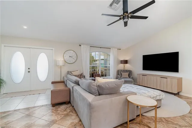 a living room with furniture a flat screen tv and a large window