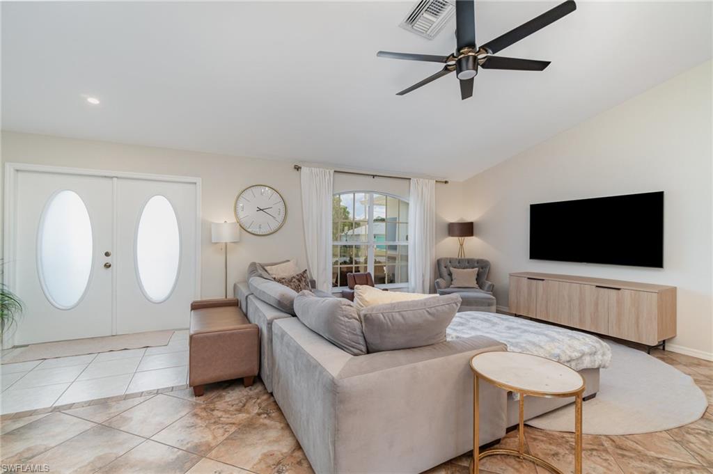879 Rue Labeau Circle Fort Myers, FL 33913 - Photo 9 of 27 a living room with furniture a flat screen tv and a large window