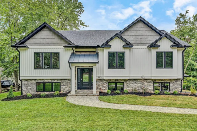 a front view of a house with a garden and yard