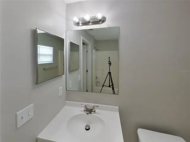 a bathroom with a toilet sink and mirror