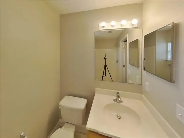 a bathroom with a sink mirror and toilet