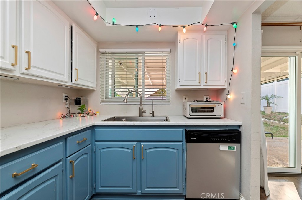 25143 Sugar Hill Road Moreno Valley, CA 92553 - Photo 15 of 28 a kitchen with stainless steel appliances granite countertop a sink a refrigerator and cabinets