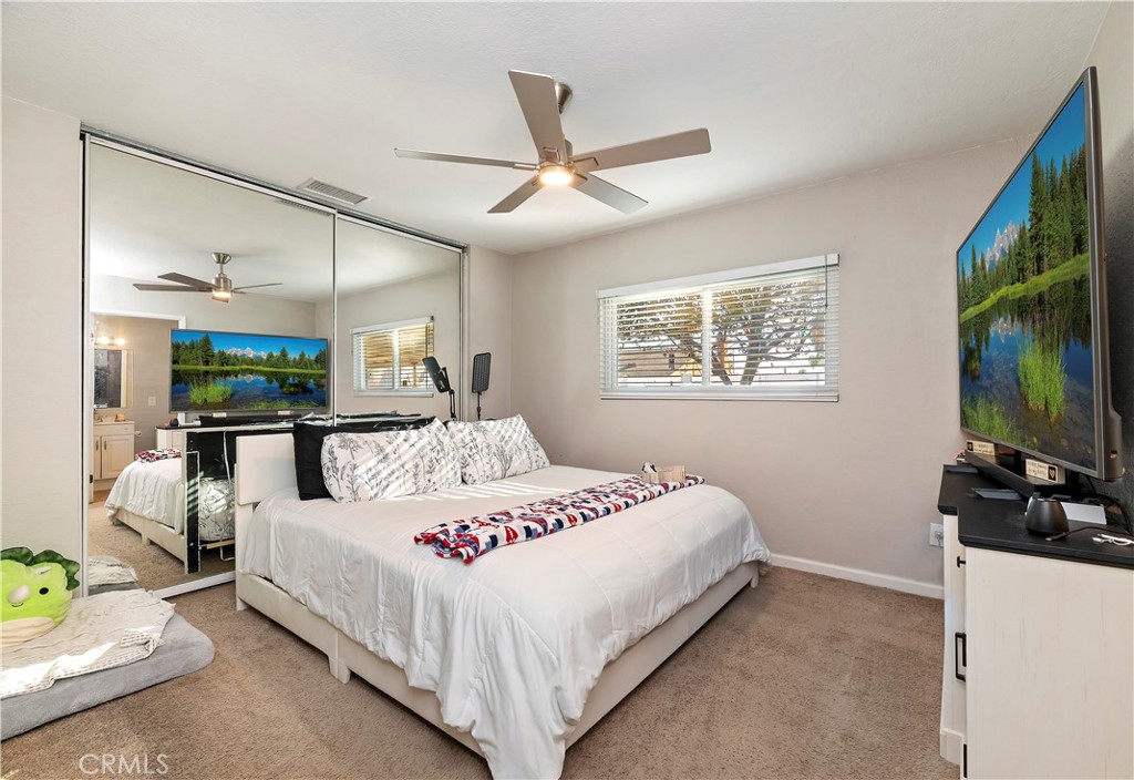 25143 Sugar Hill Road Moreno Valley, CA 92553 - Photo 17 of 28 a bedroom with a bed flat screen tv and a window