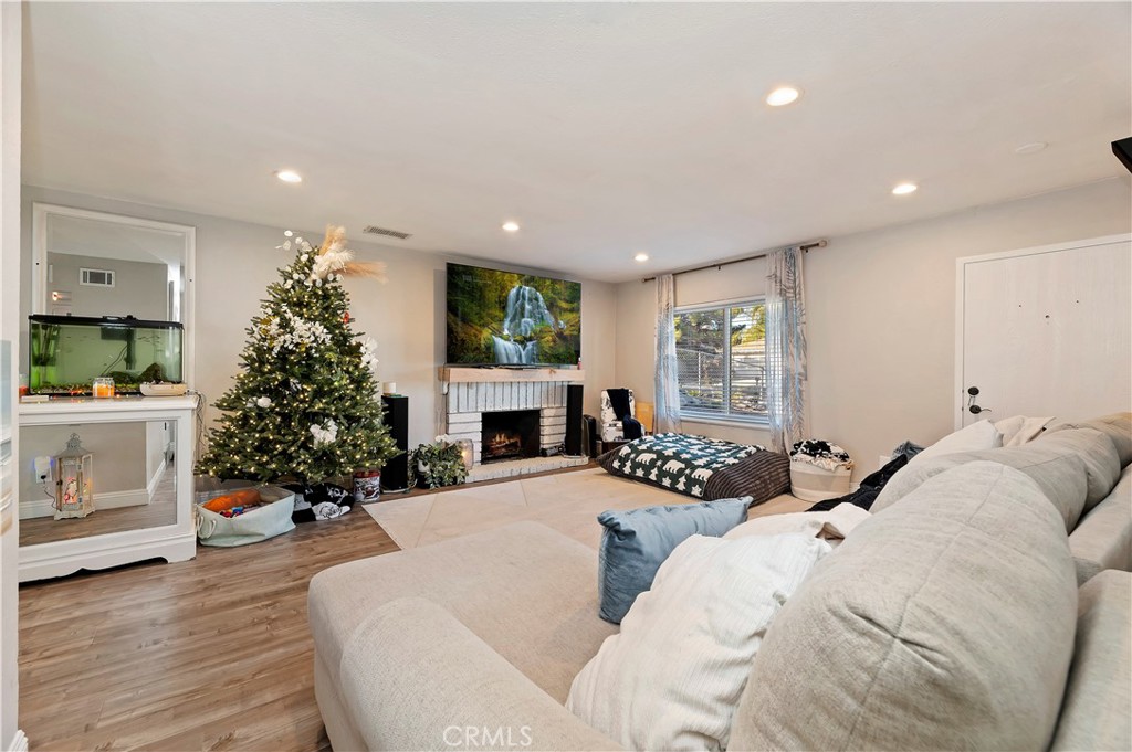 25143 Sugar Hill Road Moreno Valley, CA 92553 - Photo 8 of 28 a living room with furniture a fireplace and a potted plant