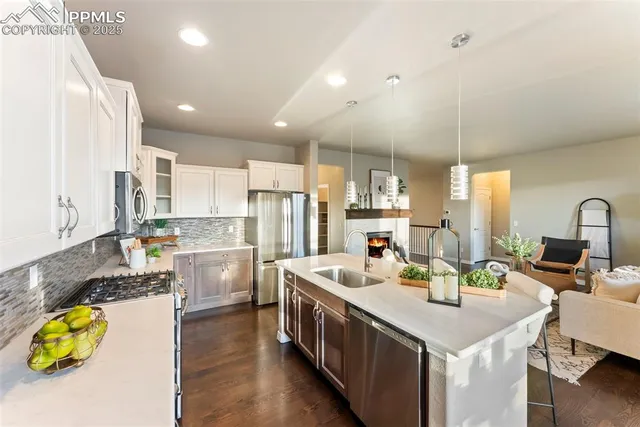 a kitchen with stainless steel appliances kitchen island granite countertop a stove a sink a refrigerator and island with wooden floor