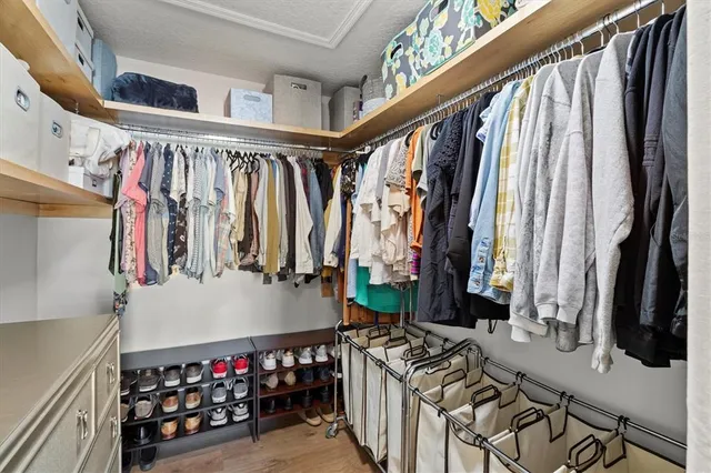 a view of walk in closet with clothes and shoes