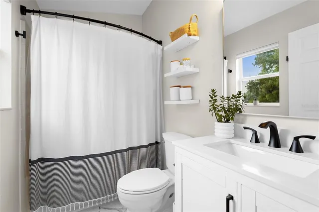 a bathroom with a sink toilet and mirror