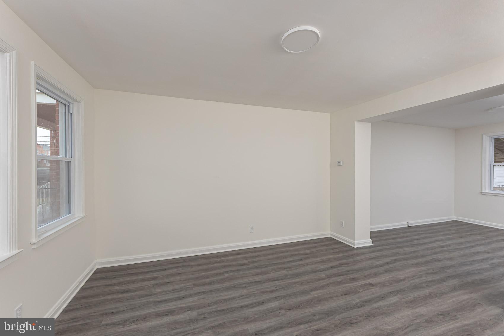 7035 Gough Street Baltimore, MD 21224 - Photo 11 of 25 a view of an empty room with wooden floor and a window
