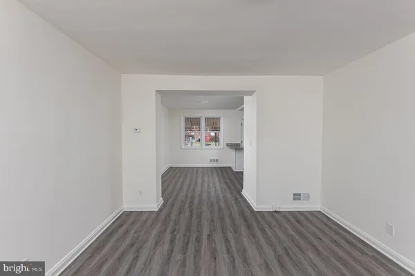 an empty room with wooden floor and a window