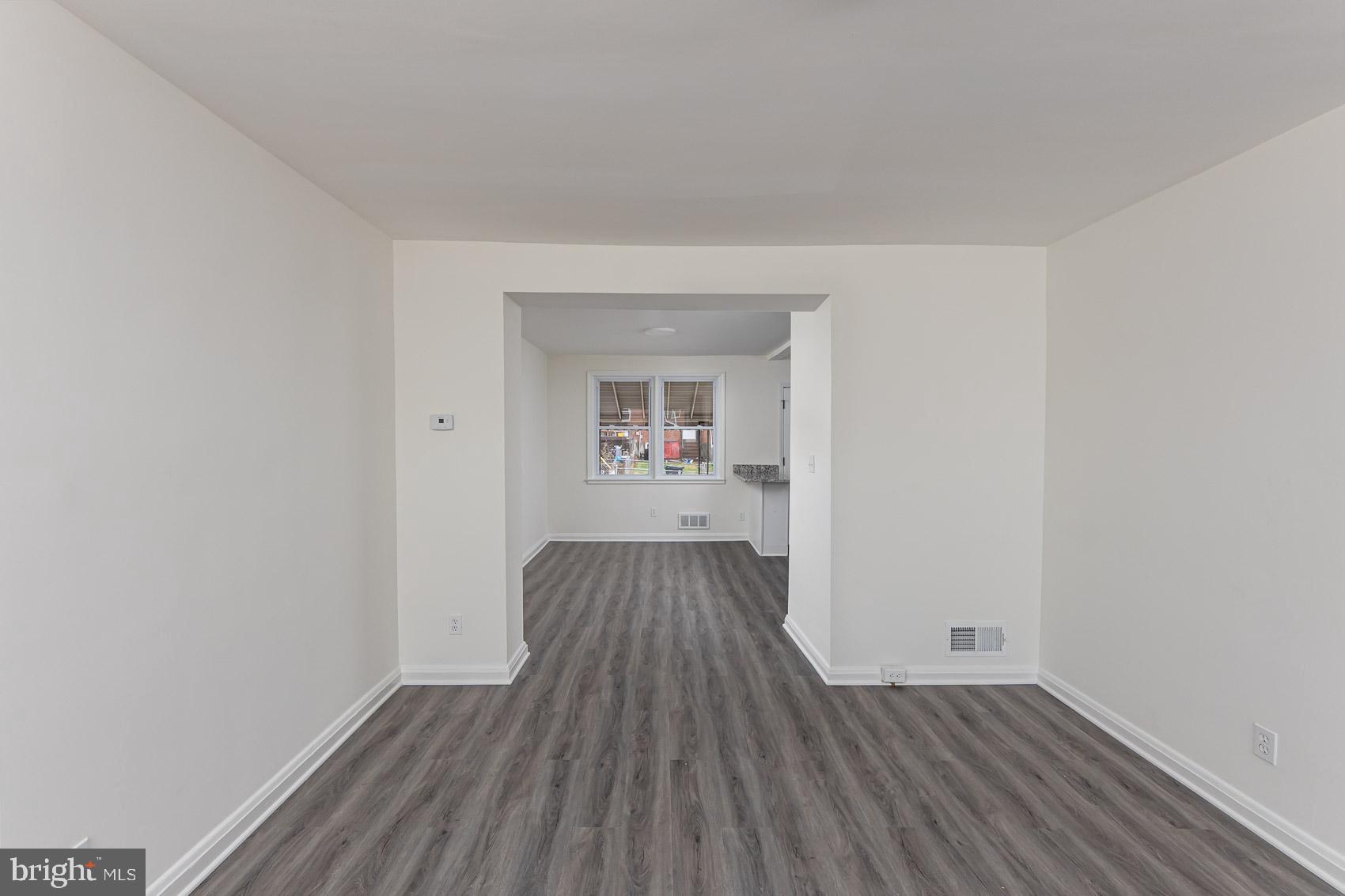 7035 Gough Street Baltimore, MD 21224 - Photo 12 of 25 an empty room with wooden floor and a window
