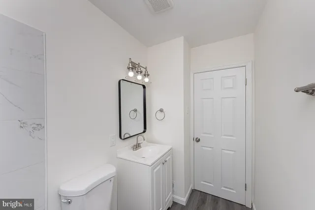 a bathroom with a toilet a sink and a mirror