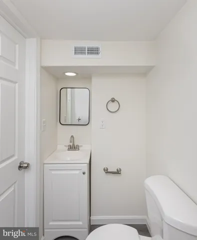 a bathroom with a toilet sink and mirror