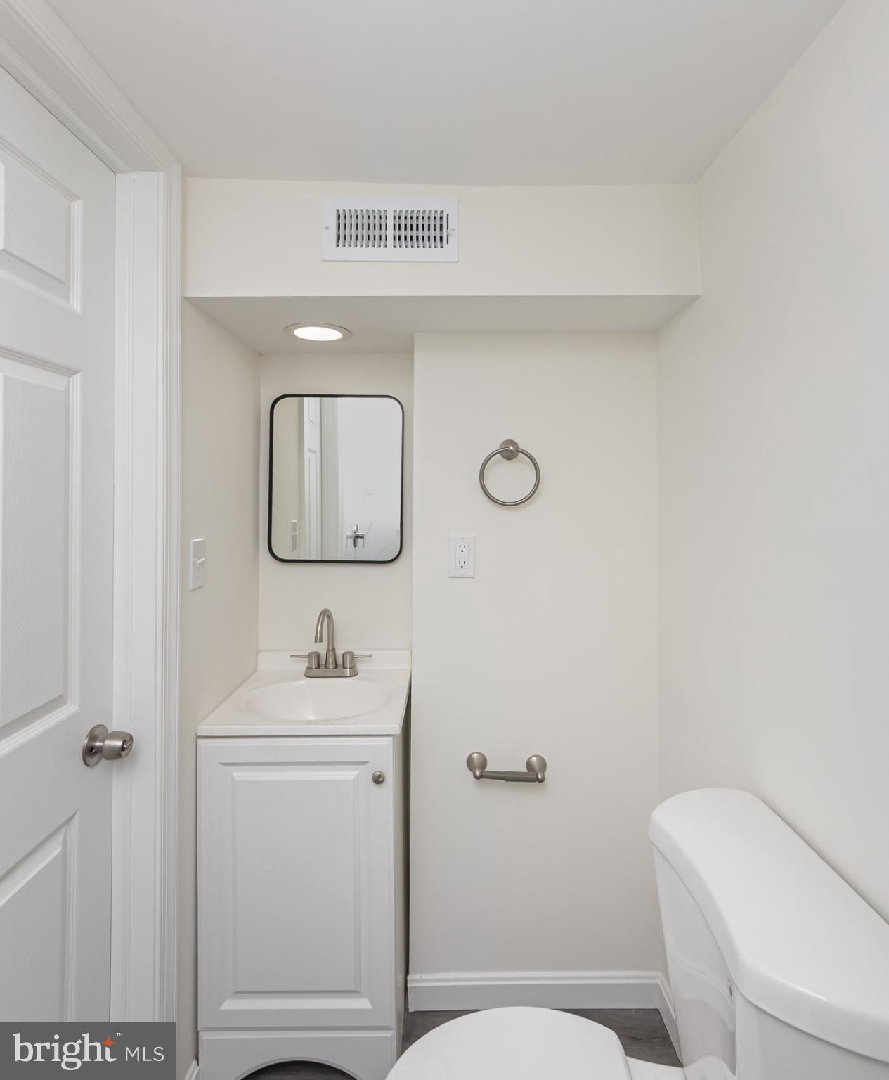 7035 Gough Street Baltimore, MD 21224 - Photo 24 of 25 a bathroom with a toilet sink and mirror