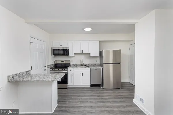 a kitchen with stainless steel appliances granite countertop a refrigerator sink and stove