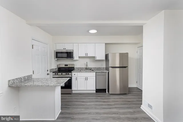 a kitchen with stainless steel appliances granite countertop a refrigerator sink and stove