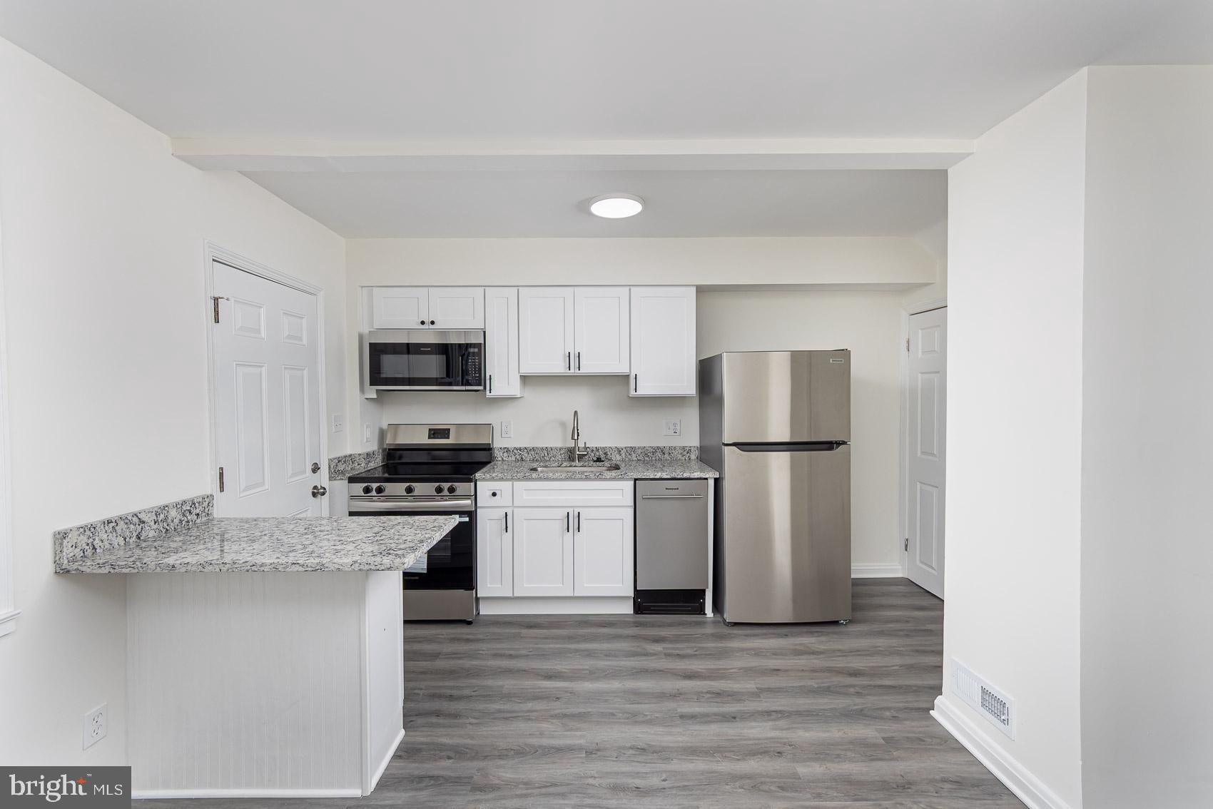 7035 Gough Street Baltimore, MD 21224 - Photo 3 of 25 a kitchen with stainless steel appliances granite countertop a refrigerator sink and stove
