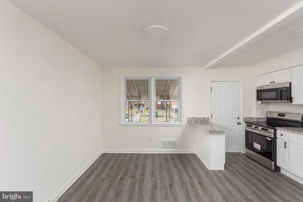 a kitchen with wooden floors and white cabinets