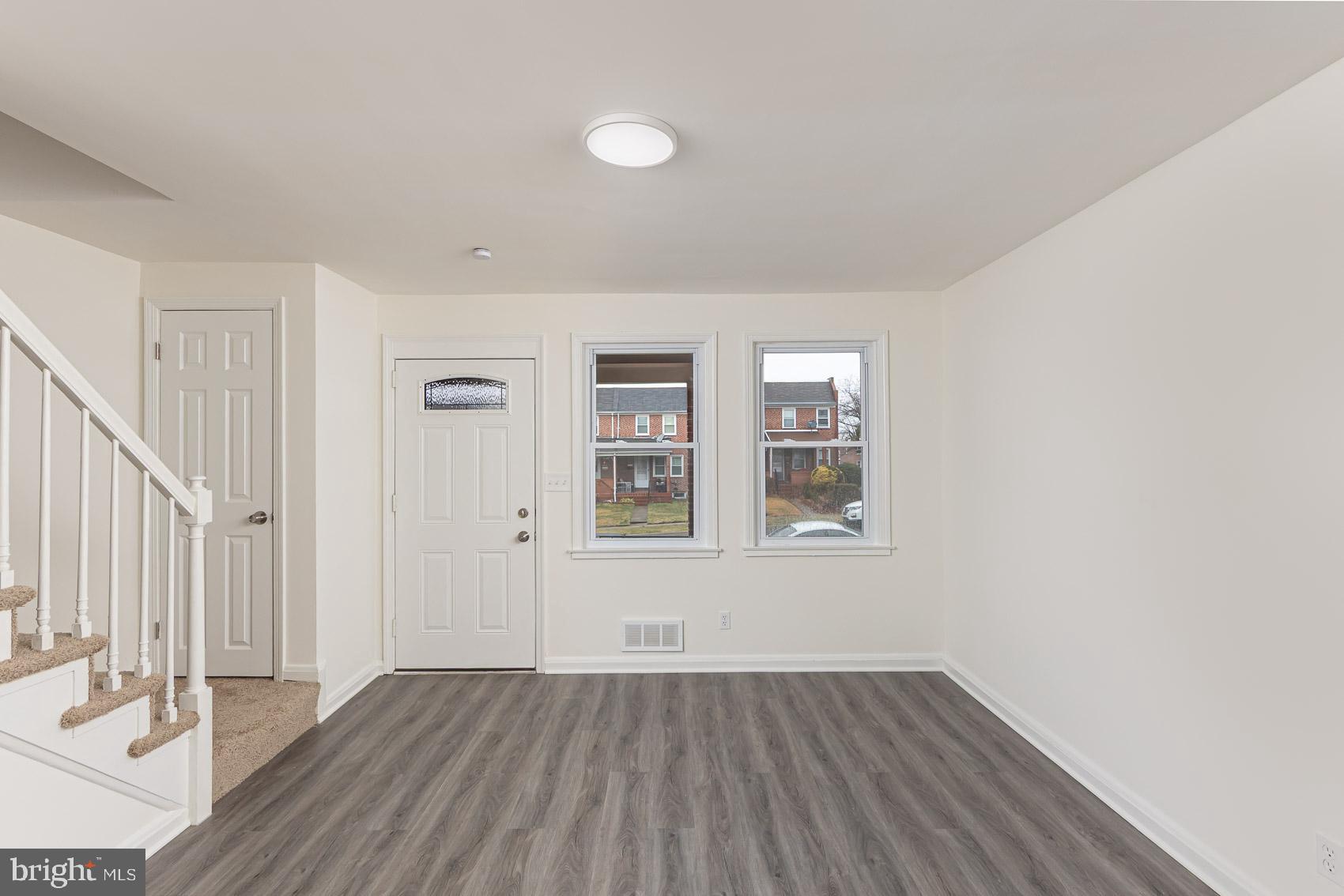 7035 Gough Street Baltimore, MD 21224 - Photo 9 of 25 an empty room with wooden floor and windows