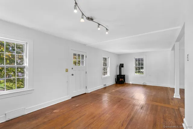 a view of a livingroom with wooden floor and windows