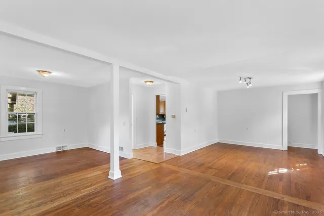 a view of empty room with wooden floor
