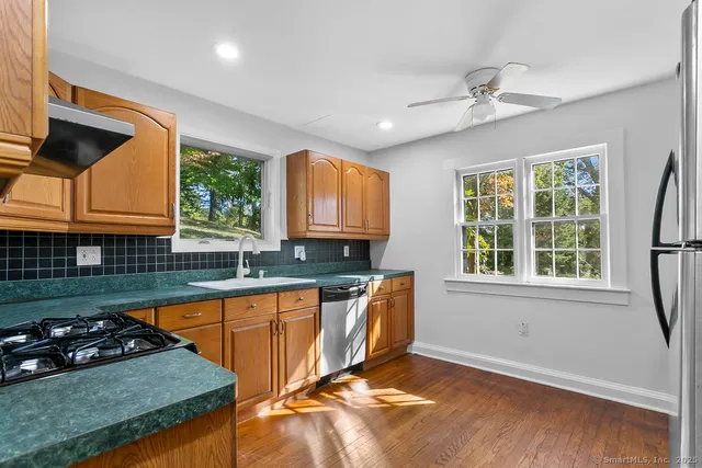 a kitchen with granite countertop stainless steel appliances a sink a counter space and a window