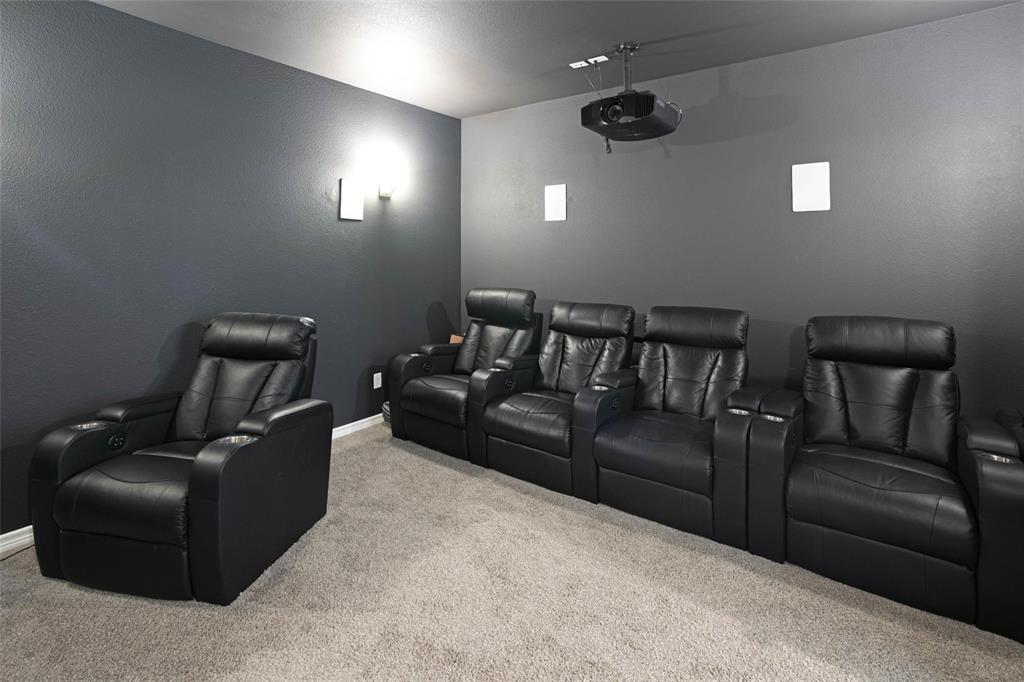 475 Massey Road Gunter, TX 75058 - Photo 24 of 34 Projector system, ceiling-mounted speakers, wall sconces, and neutral carpet flooring