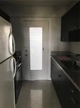 a kitchen with a refrigerator and a stove top oven