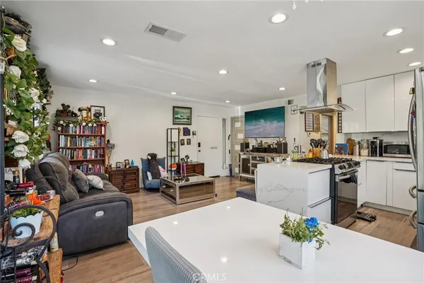 a living room with furniture and a dining table with kitchen view