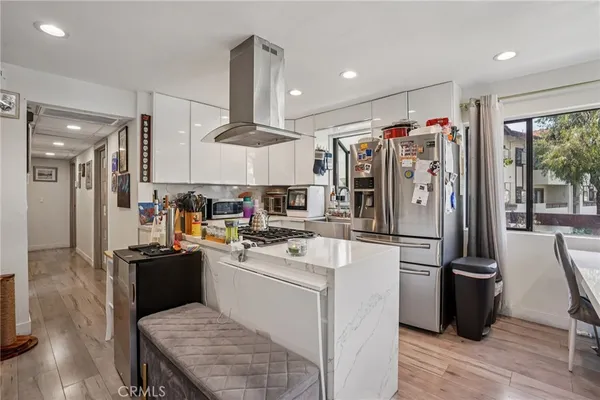 a kitchen with a sink a refrigerator and wooden floor