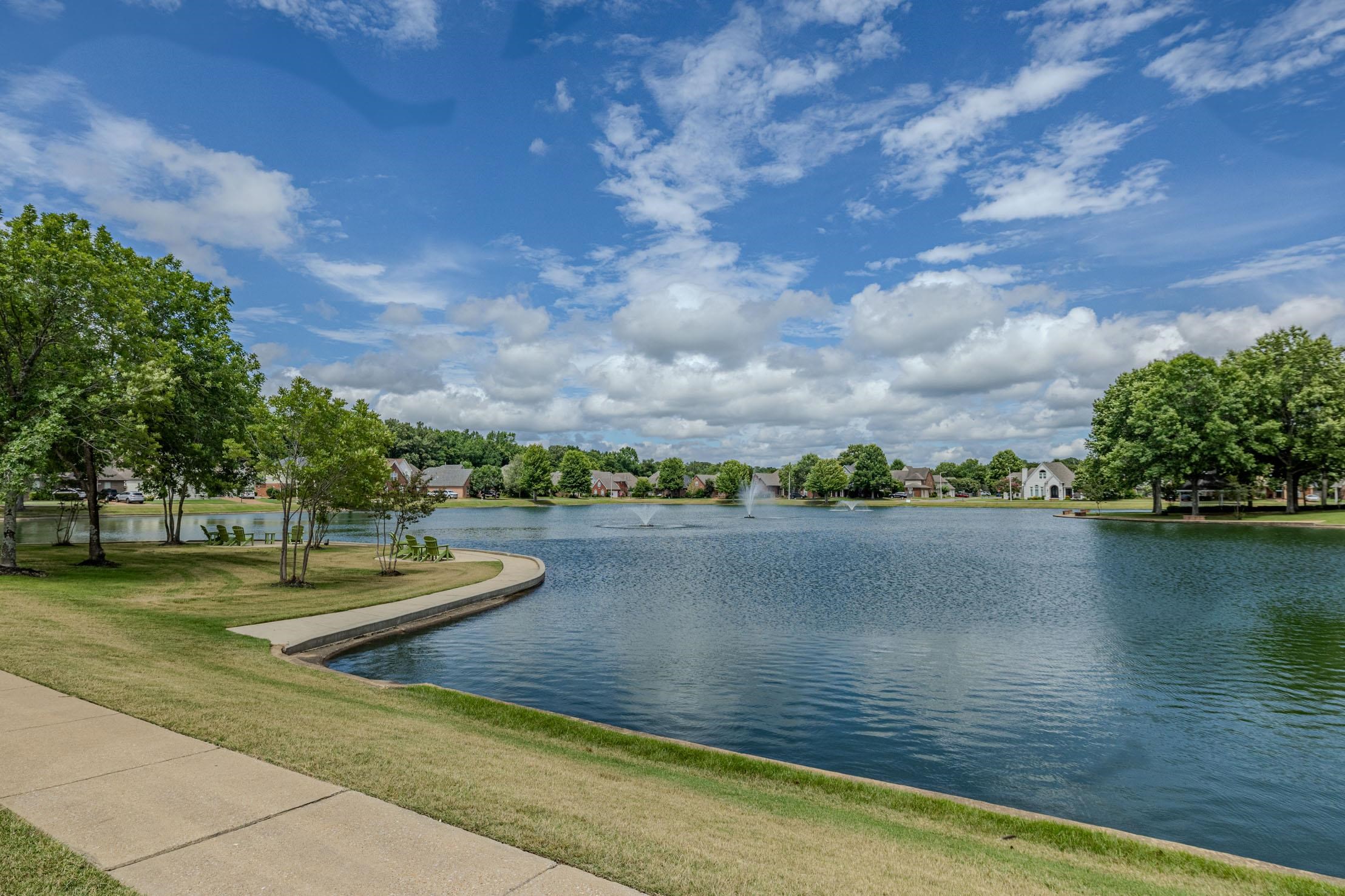 96 Berryfield Cove Collierville, TN 38017 - Photo 37 of 39 Expansive lake with fountain features, bordered by a concrete pathway and manicured green spaces