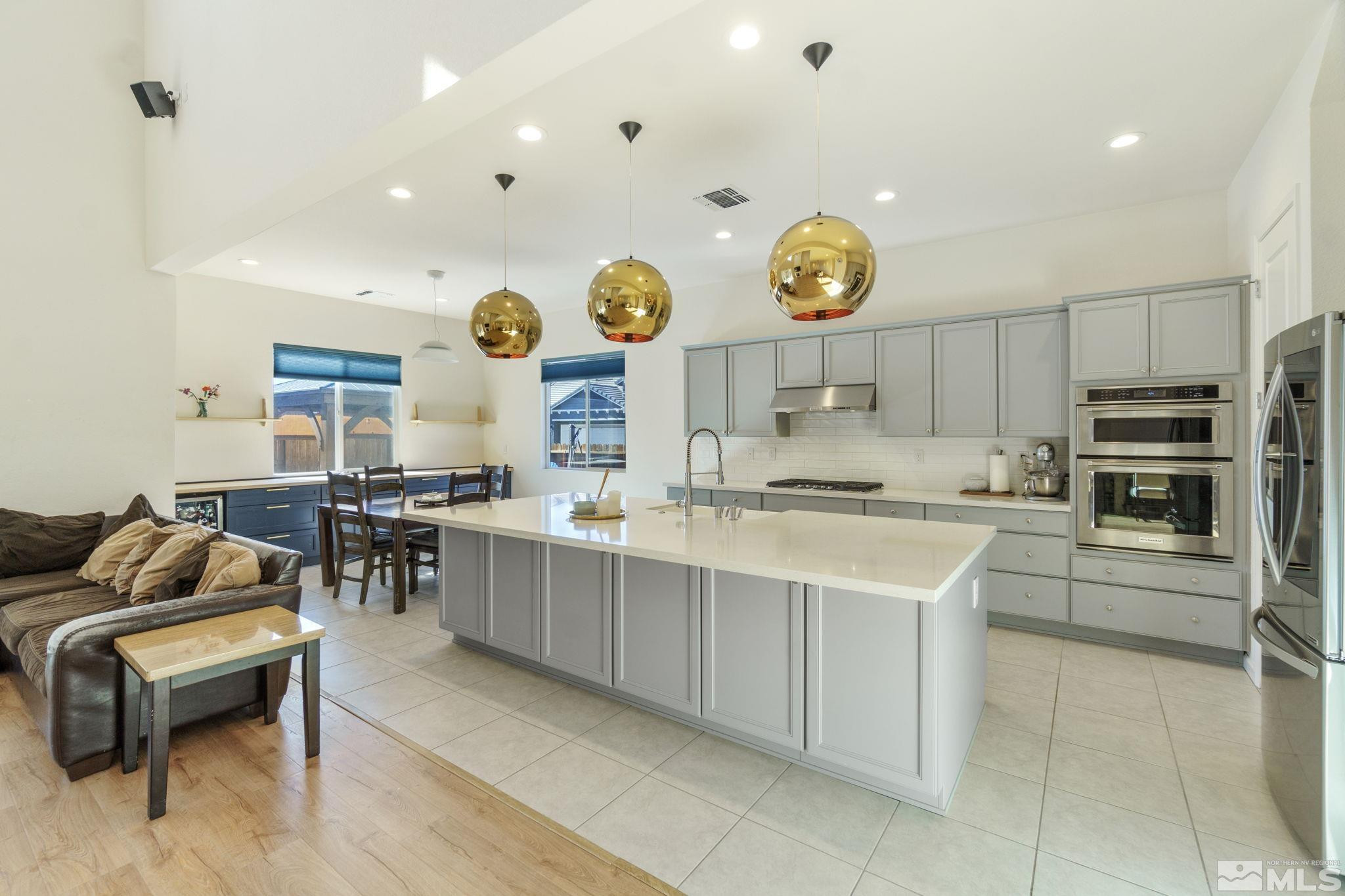 9401 Flying Horse Road Reno, NV 89521 - Photo 12 of 40 a kitchen with stainless steel appliances kitchen island granite countertop a sink and a stove