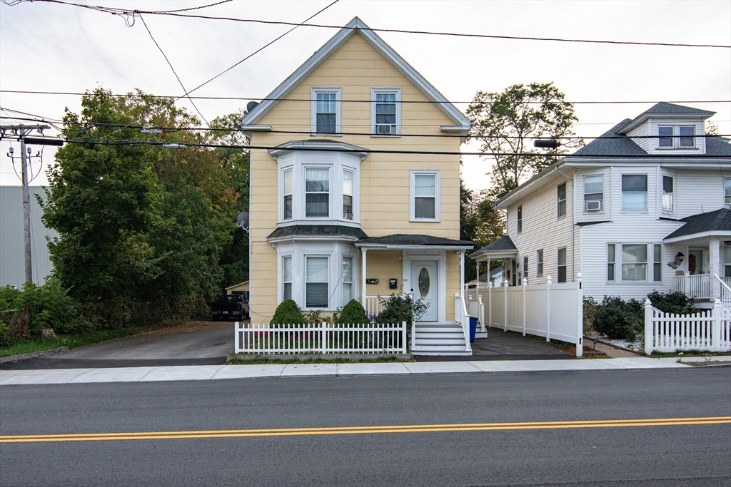 a view of a white house next to a road