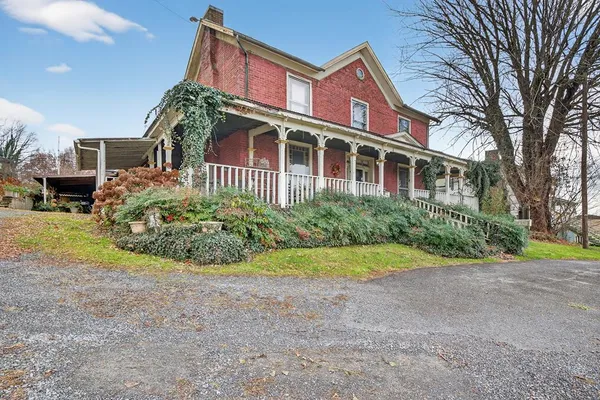a view of a house with a yard and potted plants