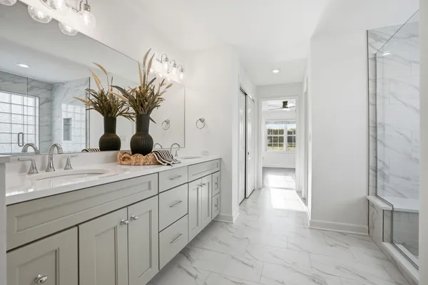 a spacious bathroom with a granite countertop sink a mirror and a shower