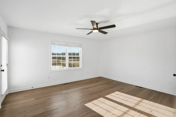 a view of a room with wooden floor and windows