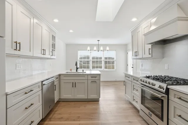 a kitchen with stainless steel appliances granite countertop a stove and a sink
