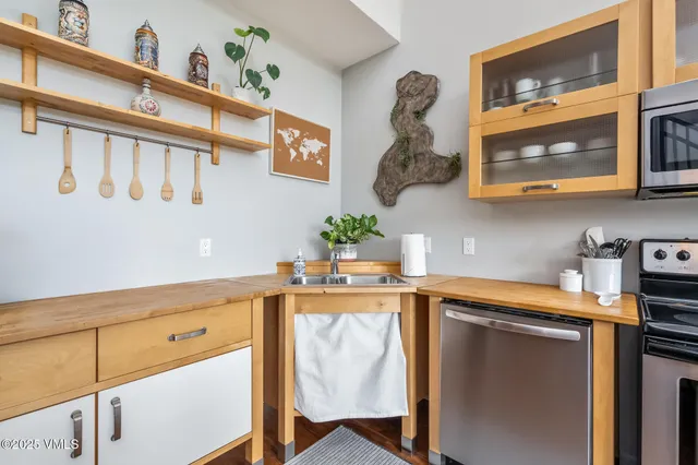 a kitchen with stainless steel appliances granite countertop a sink and wooden cabinets