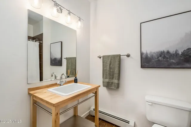 a bathroom with a sink a toilet and mirror