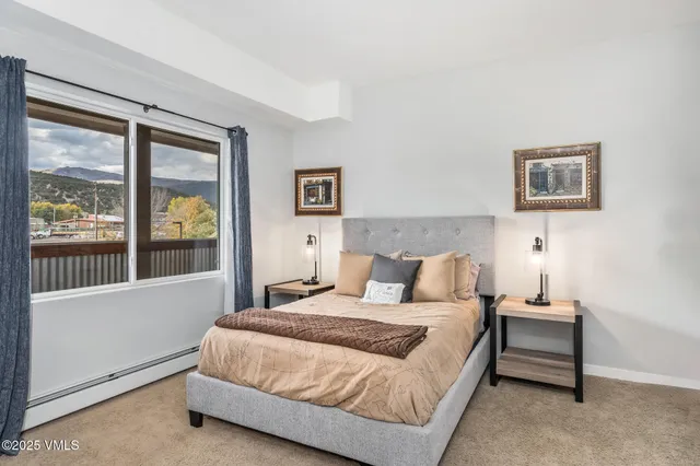 a bedroom with a bed and a large window