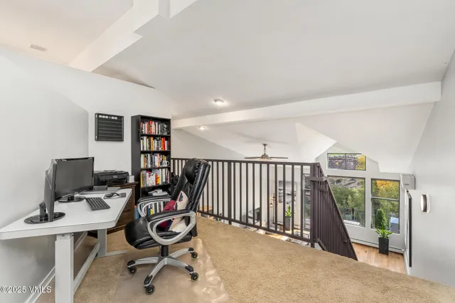 a view of a workspace with furniture and a window