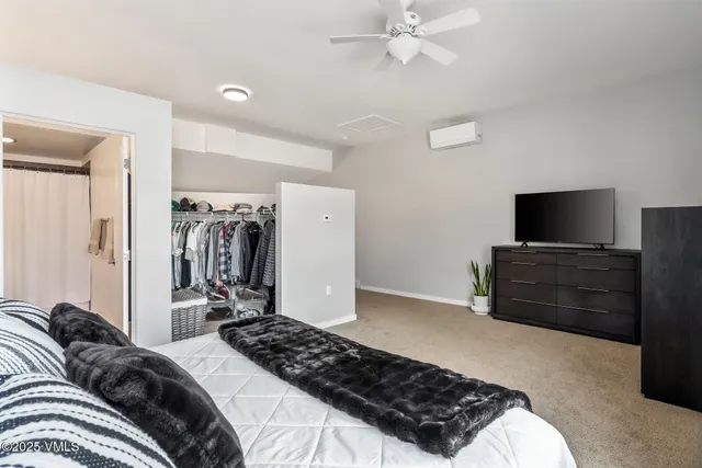 a bedroom with a bed and a flat tv screen on a dresser